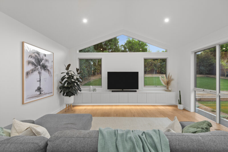 Custom joinery Ringwood – modern living room with built-in white entertainment unit and LED lighting, part of a house extension in Ringwood by Karja Builders.