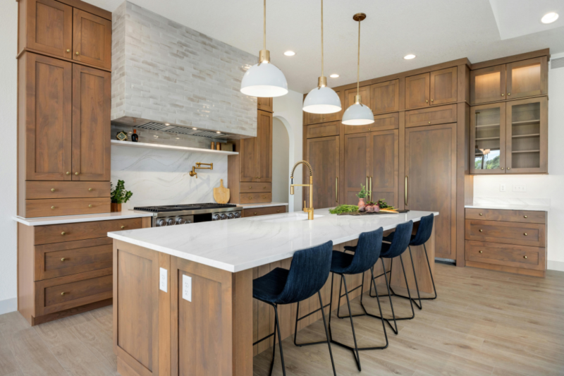 Custom kitchen renovation in a Melbourne home featuring natural stone, timber cabinetry, and elegant lighting design.