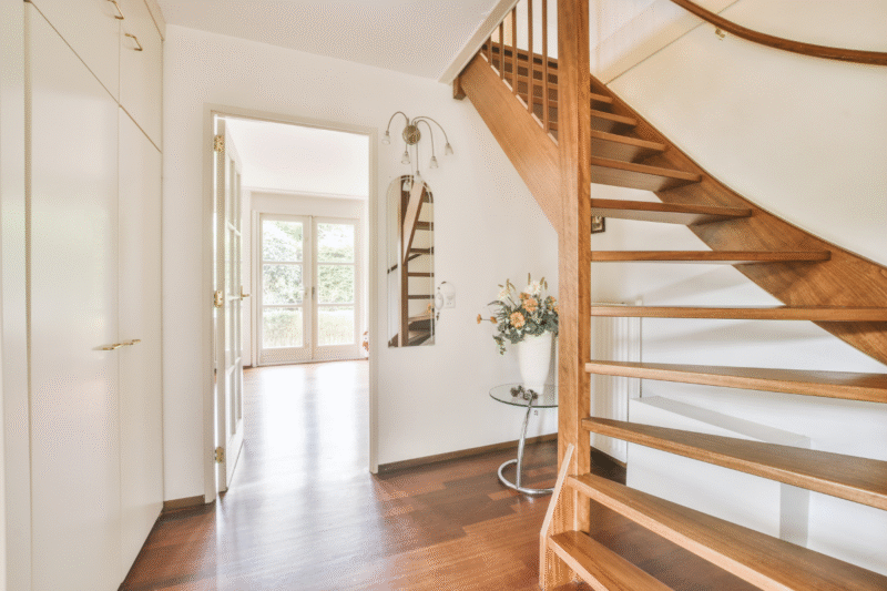 Elegant home entryway with architectural staircase, statement lighting, and bespoke finishes—crafted to elevate the first impression of your custom home.