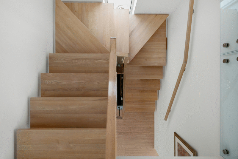 Modern timber staircase design in a contemporary home, showcasing craftsmanship often seen in high-end extensions